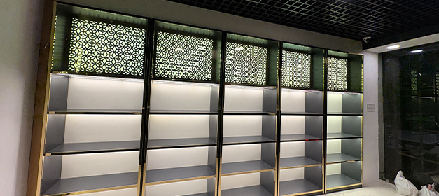 Empty illuminated liquor display rack bays with decorative header panels