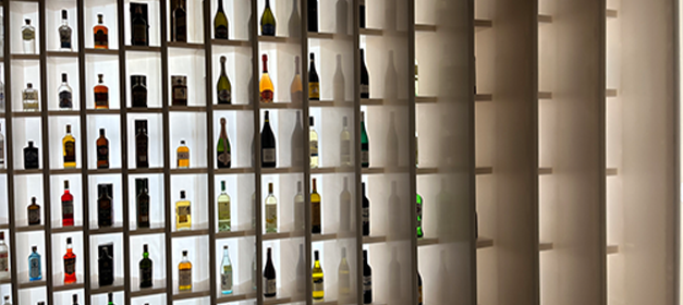 Individual bottle display cubbies in a premium liquor store rack