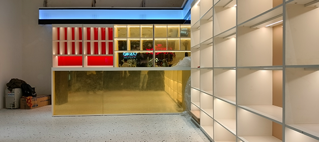 Custom illuminated liquor store shelving and display counter during fit-out
