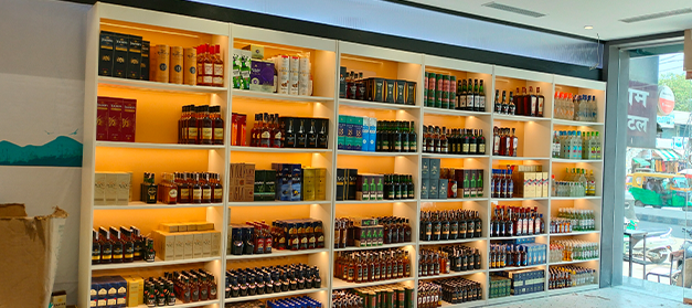 Liquor bottle display rack in a modern Indian wine shop for better product visibility, New Delhi